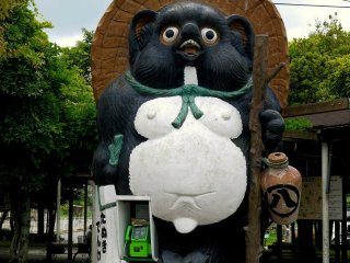 Giant tanuki and public phone outside the JR station