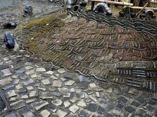 Broken tiles laid like cobbles, next to tiles laid on edge to form patterns.
