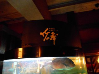 Signage of &#39;Take-no Mai (Bamboo Dance)&#39; and swimming fish in the tank