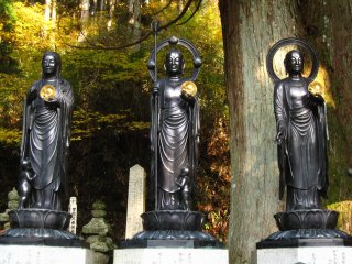 three statues each holding a&nbsp;golden disc&nbsp;with fetus engraved inside