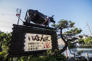 The statue of the cow atop&nbsp;Inanba&#39;s&nbsp;signboard. They really are serious about their beef.