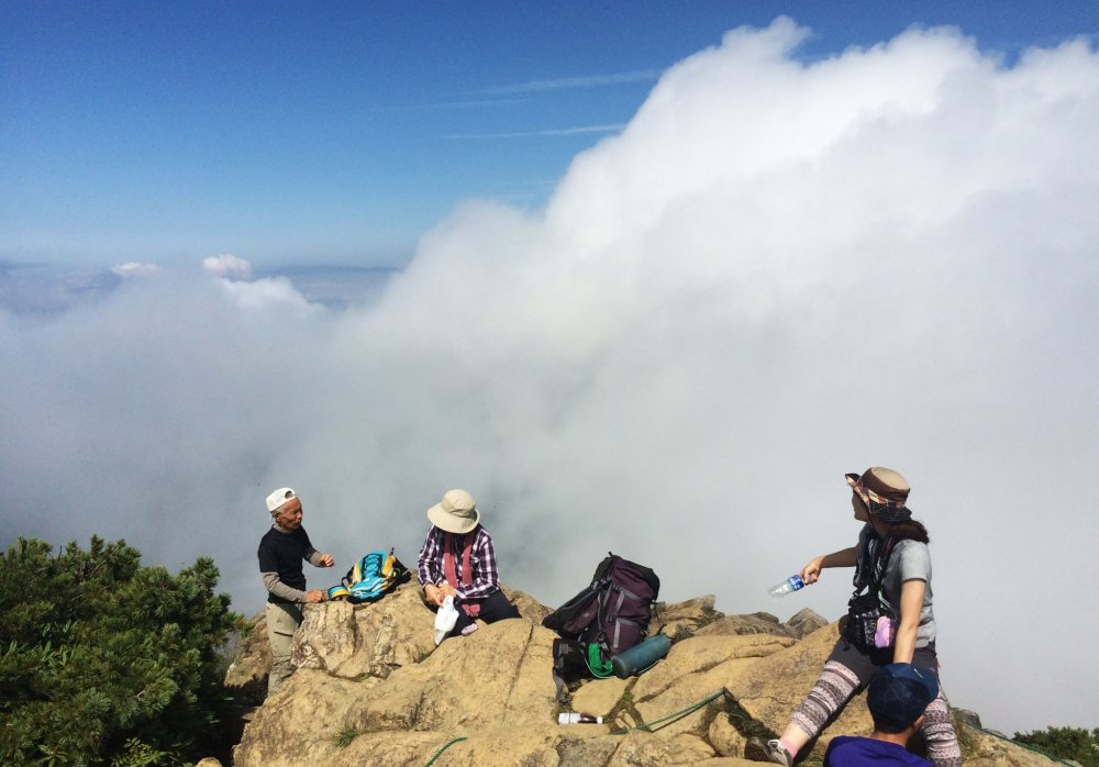 Hikers take a rest at the mountain top of Mt. Shibutsu.
