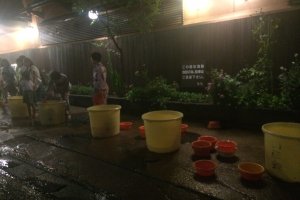 Buckets filled with hot spring water from hotels for guests and spectators to throw on the shrine.