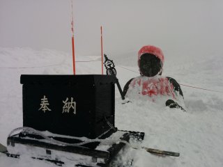 A Jizo statue buried up to its chest in the snowfall. Return during summer to see it in full