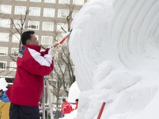 A man hard at work on his snow sculpture