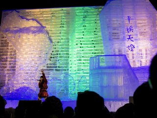 A singer performs against the illuminated backdrop of this enormous ice sculpture