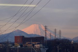 Mt. Fuji nestles in between power lines and buildings