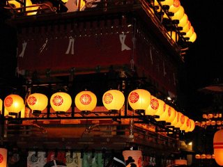 Floats are lit up with the warm light of paper lanterns