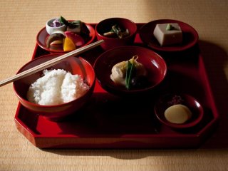The set meal consists of rice, soup, vegetables, beans and an array of bean curd variations—all served on a red lacquer tray