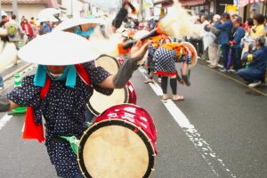 Drummers parade through the streets on their way to the rice fields