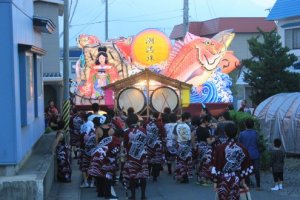 The tail end of one of the float&#39;s processions. Taiko drums attached to the back of the float, with people dancing or just chatting behind.&nbsp;
