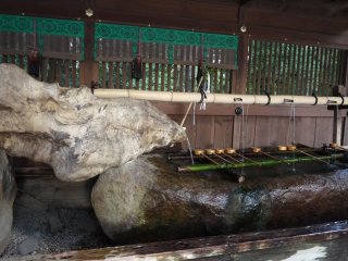 На большом камне разместились бамбуковые умывальники для ритуала очищения рук