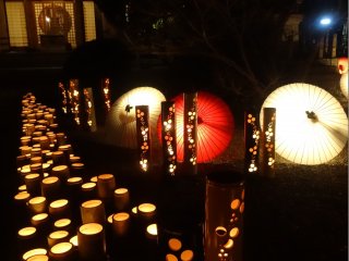 明かりの灯った和傘と竹灯籠が、山鹿湯の寺境内を照らす