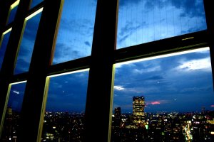 แสงสีของเมืองโตเกียวยามค่ำคืนที่มองผ่านกระจกบานใหญ่ในมุมหนึ่งบนชั้น Mani Observatory ของหอคอยโตเกียว (Tokyo Tower) ที่ระดับความสูง 150 เมตร&nbsp;