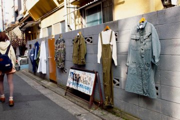 <p>เสื้อผ้าที่แขวนโชว์และขายตามกำแพงข้างถนน</p>