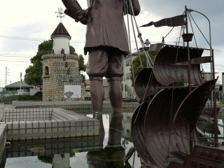 Une grande statue de Gulliver remorquant un navire de Lilliputiens devant la station Omi-Takashima