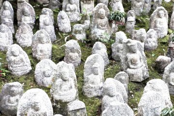 <p>A small collection of Buddhist statues to the side of the temple building</p>