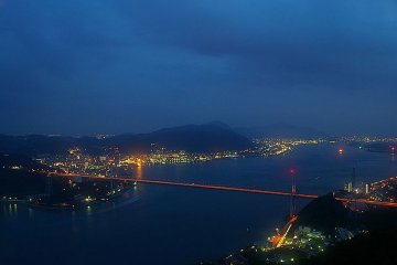 <p>ภาพวิวสะพานแขวนลอยฟ้า สะพานกันมอนเกียว (Kanmonkyo Bridge) ยามพลบค่ำ</p>