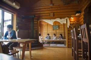 The log cabin even contains a tatami mat room next to the main dining area; note the wood-burning stove behind the table on the left
