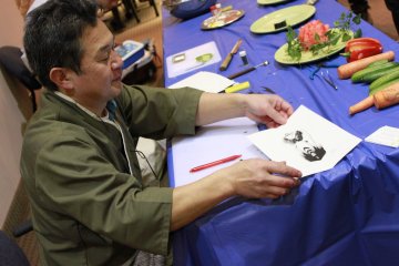 <p>Chef Sato finishing one of his paper butterflies. All his designs are extremely detailed and are cut using kitchen knives. &nbsp;</p>