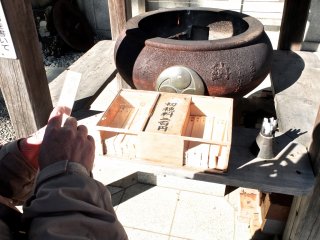 Writing out a prayer request, and then burning it, the smoke rising to reach the God of Shintoism