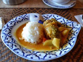 A tasty main dish of rolled cabbage, vegetables, and rice in a delicious curry sauce
