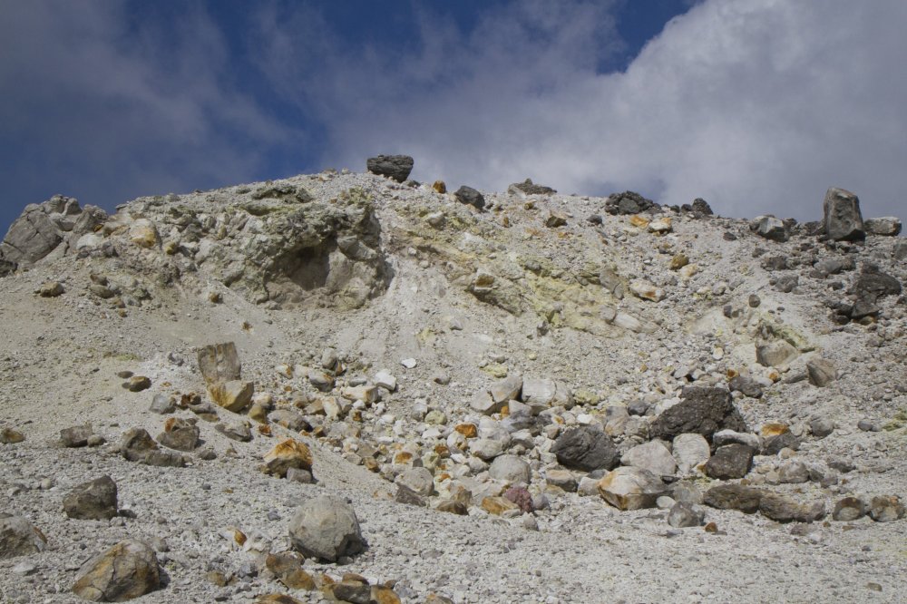 The barren peak of Mt. Io, littered with sulfur