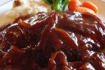 Today, this hamburger steak dish is still served up exactly as it was 80+ years ago: a Grilled hamburger with demi-glace sauce and boiled vegetables.