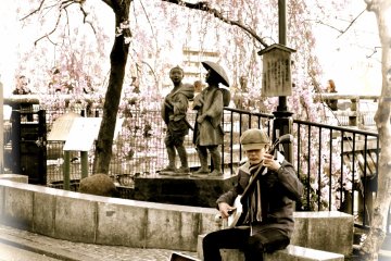 <p>A young musician has found a good spot to play</p>