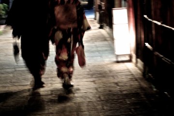 <p>A couple in kimono walking through the shadows of the night</p>