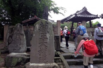 <p>Pilgrims walk past the entrance to a Daikannon temple</p>