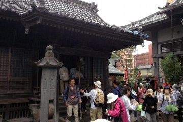 <p>A group gathers around the temple to give thanks and to ask for blessings</p>