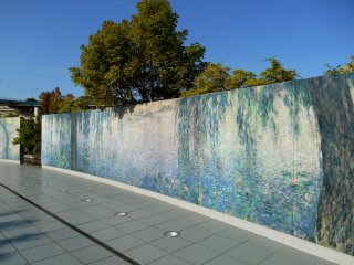 Monet&#39;s Nympheas reproduced on the wall in the garden. As these ceramic boards are durable, these paintings can be displayed outdoors as well