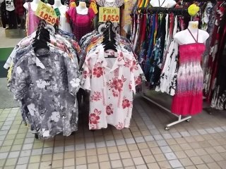 There are lots of colorful shirts and dresses for sale