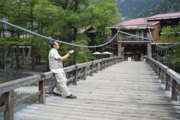 <p>A visitor sketching the beauty of the Hokata mountain range at the Kappabashi bridge</p>