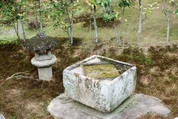 There are many stone lanterns and wash basins set along the garden baths