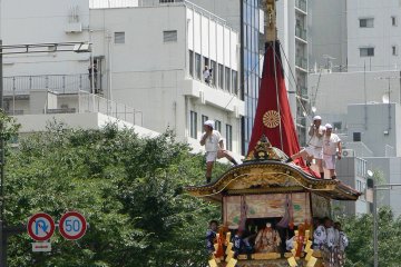 <p>The guys on top help steady the tall float</p>