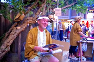 Um homem distribui leques no Templo de Kishimojin em Iriya