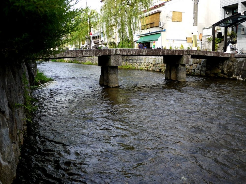 Jembatan sempit batu melintasi Shirakawa yang mengalir antara Sanjo dan Shijo