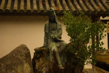 <p>Outside in the front garden of the temple, a statue sits silently</p>