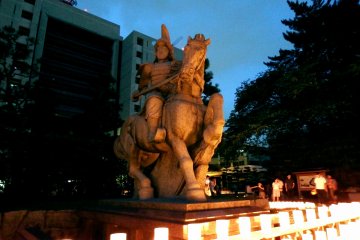 <p>The statue of the first lord of Fukui Han (domain), Yuki Hideyasu, looks different tonight under the warm lights of the lanterns</p>