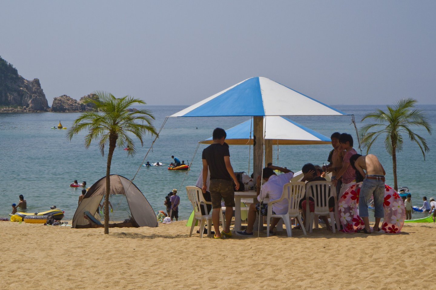 Rumah pantai menyediakan parasol besar dan tempat duduk di pantai