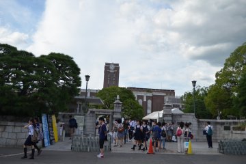 <p>บรรยากาศประตูทางเข้า มีนักเรียนม.ปลายจำนวนมากมายืนรอถ่ายรูปคู่กับป้ายชื่อมหาวิทยาลัย</p>