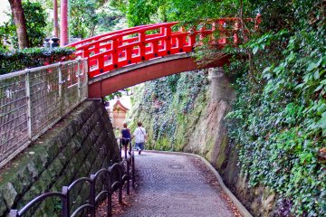<p>A beautiful red bridge on a downward slope leading back to the main entrance of the shrine</p>