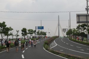 Folks walk towards Ashida River Bridge to find the perfect viewing spot