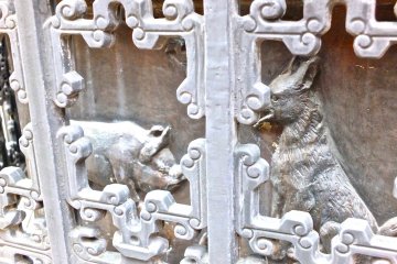 <p>A small iron fence surrounds this column of Chinese Zodiac carvings&nbsp;at Masobyo - Yokohama Chinatown.</p>