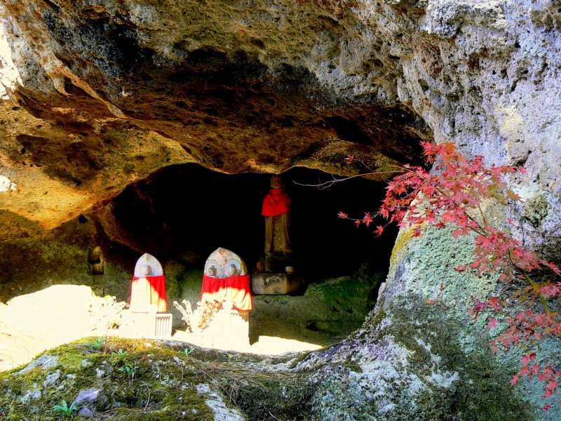 동굴들 중 하나의 입구에 빨간 두건을 두른 석상