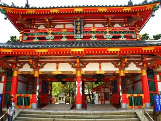 山門　京都御所・紫宸殿の御門（白木造り）と同じ様式ではあるが、これはその大半を鋼鉄で造っておりそのうえに朱を塗りこんでいる。