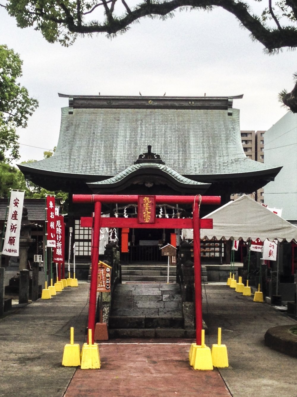 Cổng torii khác nhỏ hơn và đỏ chói đứng trước một cây cầu đá đặc biệt