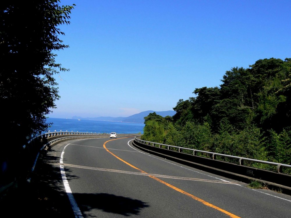 The road follows the curves of the coastline